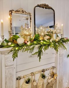 a mantel with stockings and candles on it, decorated for the christmas season in front of a mirror