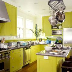 a kitchen with yellow cabinets and stainless steel appliances