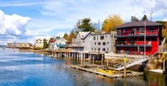 a body of water with houses on the other side and boats in the water next to it