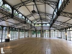 an empty room with large windows and wooden floors