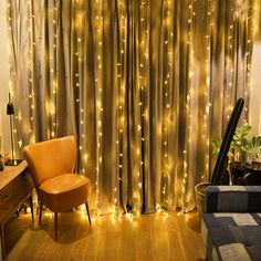 a living room with lights on the curtains and a chair in front of a couch