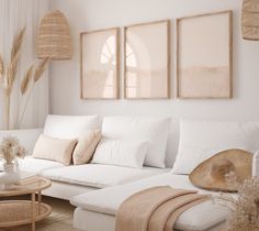 a living room filled with white furniture and lots of natural items on the table in front of it