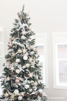 a white christmas tree with silver and gold ornaments