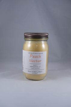 a jar of peach nectar sits on a white surface