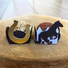 two paper cut out animals sitting on top of a wooden table