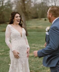 a woman in a wedding dress standing next to a man