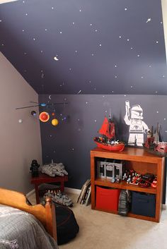 a bedroom with a star wars theme painted on the wall and ceiling, along with other items