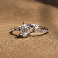 a close up of a diamond ring on a brown surface