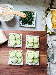 cucumber slices cut into squares on top of a cutting board next to chips