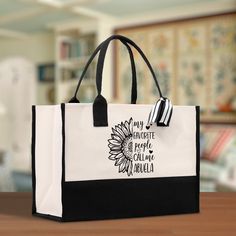 a black and white shopping bag sitting on top of a wooden table