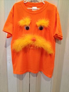 an orange t - shirt with fake eyes and a mustache on it's chest