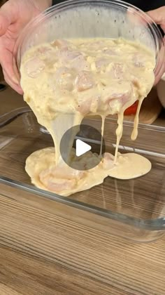 someone pouring batter into a bowl on top of a wooden table