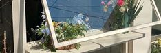 a window sill with flowers and plants in it