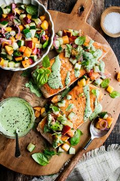 salmon with avocado dressing on a wooden platter