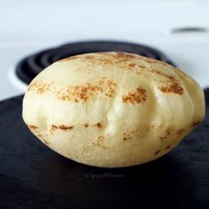 a piece of bread sitting on top of a black plate next to an electric stove