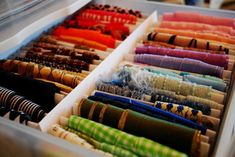 an open drawer filled with lots of different colored fabrics