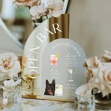 a table topped with vases filled with white flowers and small glass vases next to each other