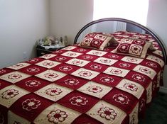 a bed with a red and white bedspread in a bedroom next to a window