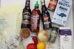 an assortment of food items are displayed on a white counter top, including tomatoes, onions, garlic, and seasonings