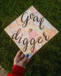 someone holding up a graduation cap that says, goal digger