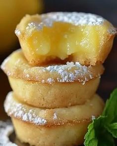 a stack of lemon filled pastries with powdered sugar on top and mint sprigs