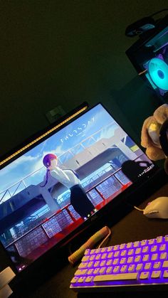 a computer desk with a keyboard, mouse and monitor on it in front of a neon light