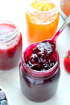 blueberries and raspberry jam in jars with spoon