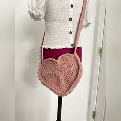 a mannequin with a crochet heart purse on it's chest