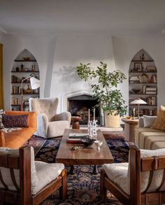 a living room filled with furniture and a fire place in the middle of a room