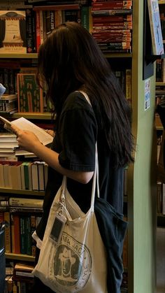 a woman standing in front of a bookshelf with a book bag on her shoulder