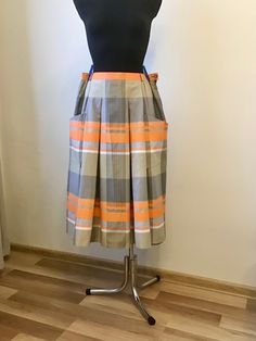 "Vintage Woman's Gray Beige  Orange Color Pleated Skirt Pockets Front Light Summer Skirt Brand: Bardehle Fabric: 70% Cotton 30% Polyester  Lining : 100% Polyester  Tag Size: 44 Fits like Size L Please rely on measurements. Measurements (taken from seam to seam while the garment is lying. Double the waist.):  Waist: 16,5\"/ 42cm. Length: 29,5\"/ 75cm. Please double check measurements to insure a proper fit. Remember to allow yourself some extra room for movement. You can compare this with something from your closet that fits you well. Please note that color may slightly vary from photos. SHIPPING  I ship worldwide via Priority mail (Latvijas Pasts) from Latvia. I ship from Europe so please allow 2 to 4 weeks for the package to arrive if you live overseas. Europe 5-10 business days. 3" Retro Flared Skirt With Pockets, Retro Mini Skirt With Pockets, Orange Lined Skirt For Workwear, Orange Workwear Skirt With Lining, Orange Skirt For Workwear In Summer, Orange Lined Skirt For Work, Orange Skirt Bottoms With Pockets, Orange Summer Skirt With Pockets, Retro Pleated Work Skirt