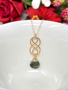 "Seraphinite is a gemstone named after Seraphim angels, as the stone has luminous, silvery \"feather\" growths that sweep throughout the stone. This beauty features AAA, natural seraphinite with beautiful color saturation. The mesmerizing, velvety green is so lush! The stone is gracefully suspended from a dainty, sparkling chain and hand-forged Celtic style knot with beautiful hammered detailing. The necklace is finished with a polished lobster claw clasp. Pendant is approximately 1.25 in length Seraphim Angels, Celtic Knot Jewelry, Schmuck Gold, Knot Jewelry, Celtic Knot Necklace, Beauty Features, Celtic Style, Knot Necklace, Celtic Knot