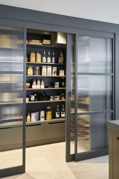 an open pantry with lots of food items on the shelves and in front of glass doors