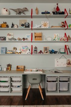 a room with shelves filled with toys and other items on top of each shelf in front of the wall