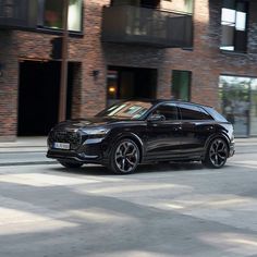 a black suv parked in front of a brick building