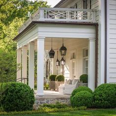 a white house with two lamps on the porch