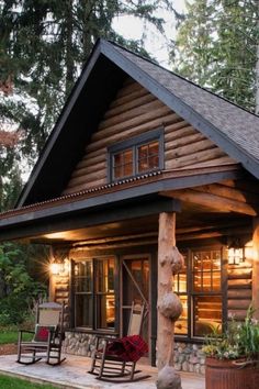 a log cabin with rocking chairs on the front porch and covered in wood shingles