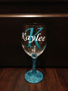 a wine glass with the name kaylee on it sitting on a wooden table top