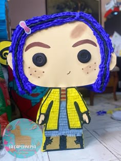 a close up of a paper doll with blue dreadlocks on it's head