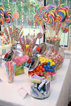 a table topped with lots of candy and lollipops on top of it