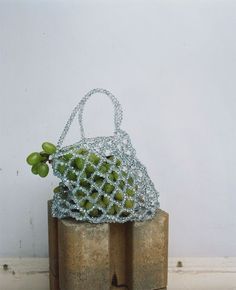 a small bag sitting on top of two wooden blocks with string wrapped around the handles