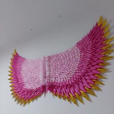 pink and gold paper sculpture hanging on the wall