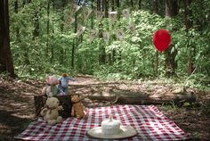 a picnic blanket with teddy bears on it in the woods