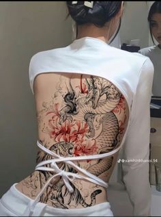 the back of a woman's body with tattoos on it