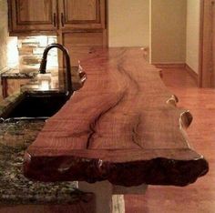 a kitchen counter made out of wood with birds on the edge and sink in the background