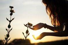 a woman holding a flower in front of the sun with a quote above it that reads, it is your light that lights the world