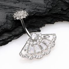 Add some sparkle to your style with our Majestic Fan belly button ring. Featuring brilliant internally threaded gems, this ring is sure to catch the light and draw attention. Elevate your piercing and show off your unique style with this dazzling accessory. * Material: 316L Stainless Steel * Bar Size: 14 GA (1.6mm), 10mm (3/8") * Length: 1.1 inch (27mm) * Width: 0.9 inch (22mm) * Internally Threaded Suitable for * Navel Piercings It is always recommended to know your exact piercing size to ensur Heavy Sweating, Navel Piercing, Stainless Steel Bar, Belly Button Ring, Button Ring, Steel Bar, Belly Rings, Belly Button, Jewelry Plate