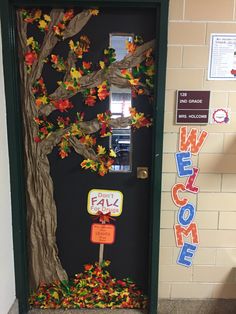 a door decorated with fall leaves and a welcome sign