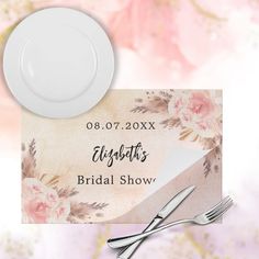 a white plate and silverware sitting on top of a floral table cloth with the name ellsworth's bridal show