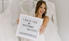 a woman holding up a sign that says i said yes wedding shoppe shopper bride